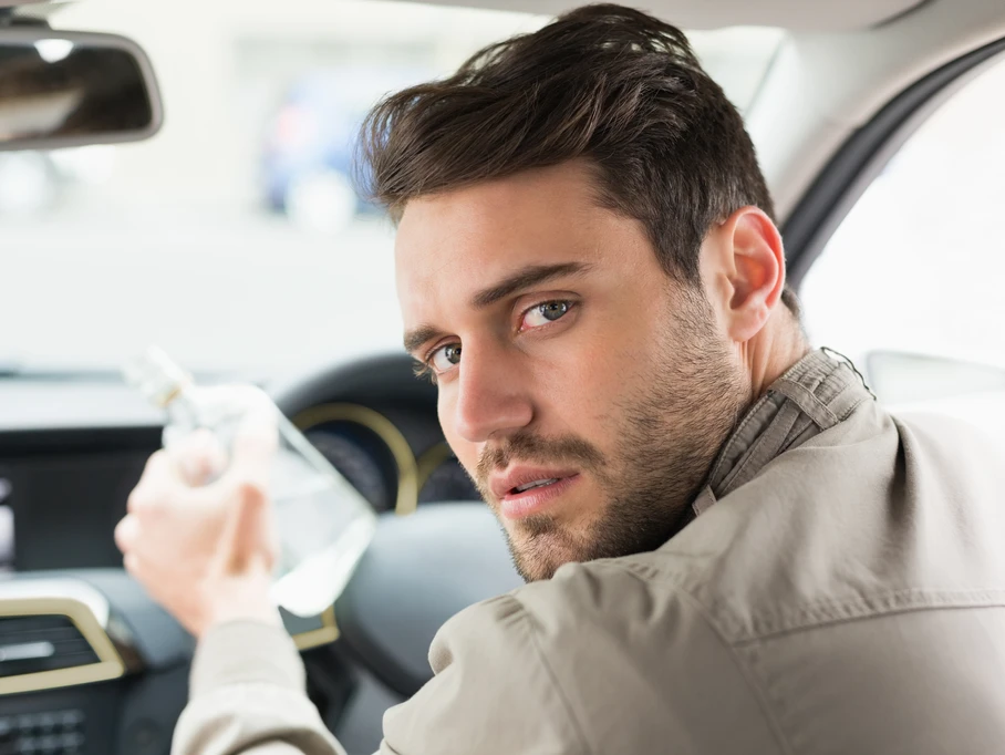 A man is behind the wheel of a vehicle looking confused and concerned.