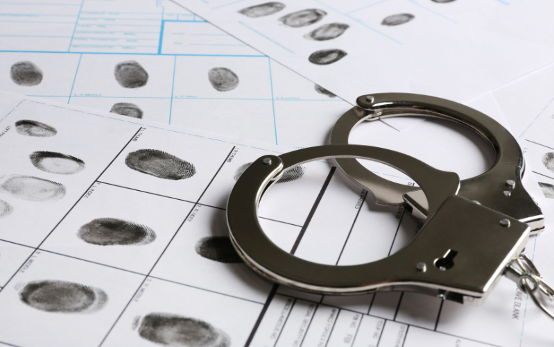 A pair of handcuffs is resting on paperwork used to fingerprint persons charged with a Michigan OWI.