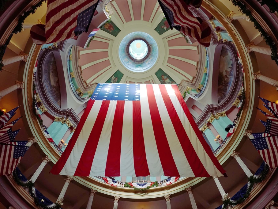 The Michigan state courthouse with a giant American flag hanging in the middle.