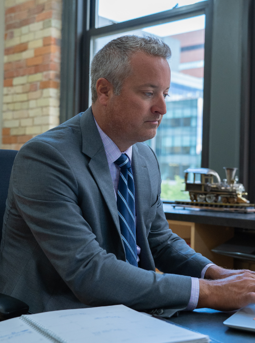 Attorney Mark M. Caldwell is working at his desk in his Grand Rapids office.