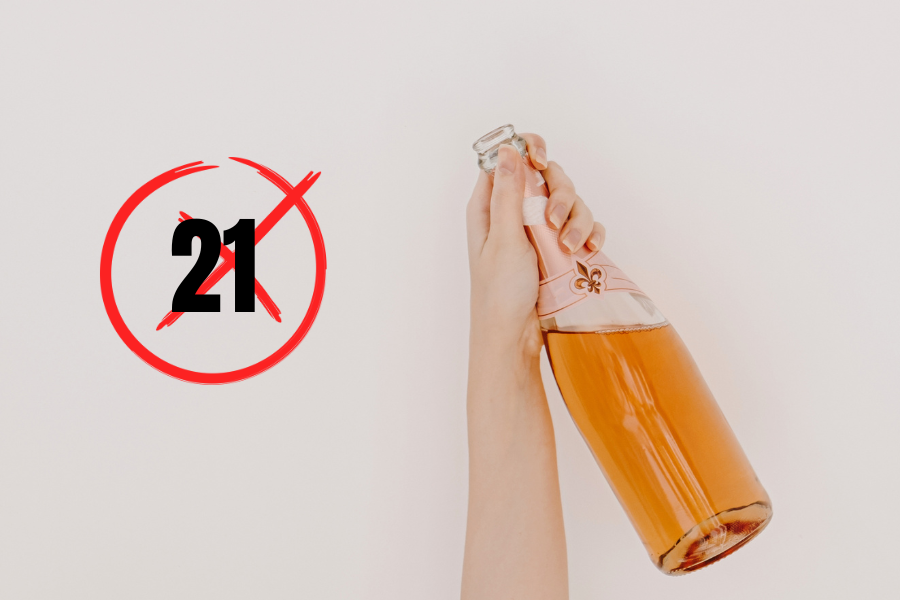 The hand of a minor holds a bottle of alcohol next to a graphic that shows a red X over the number 21.