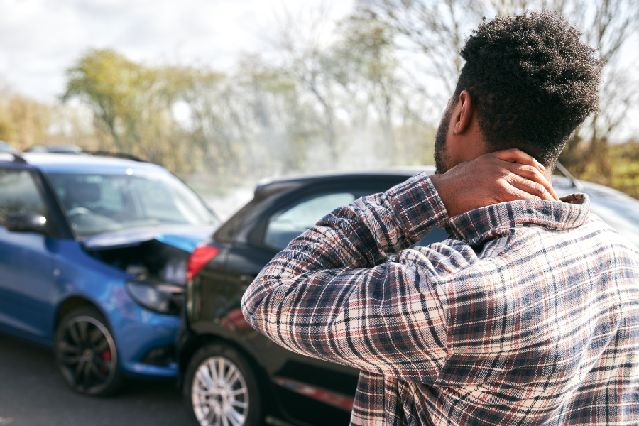 A man looks at the damage of two cars in an accident