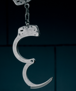 A pair of handcuffs with one side locked and the other side open