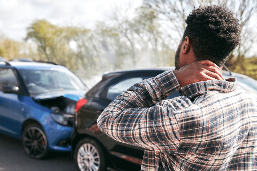 A man looks at the damage of two cars in an accident